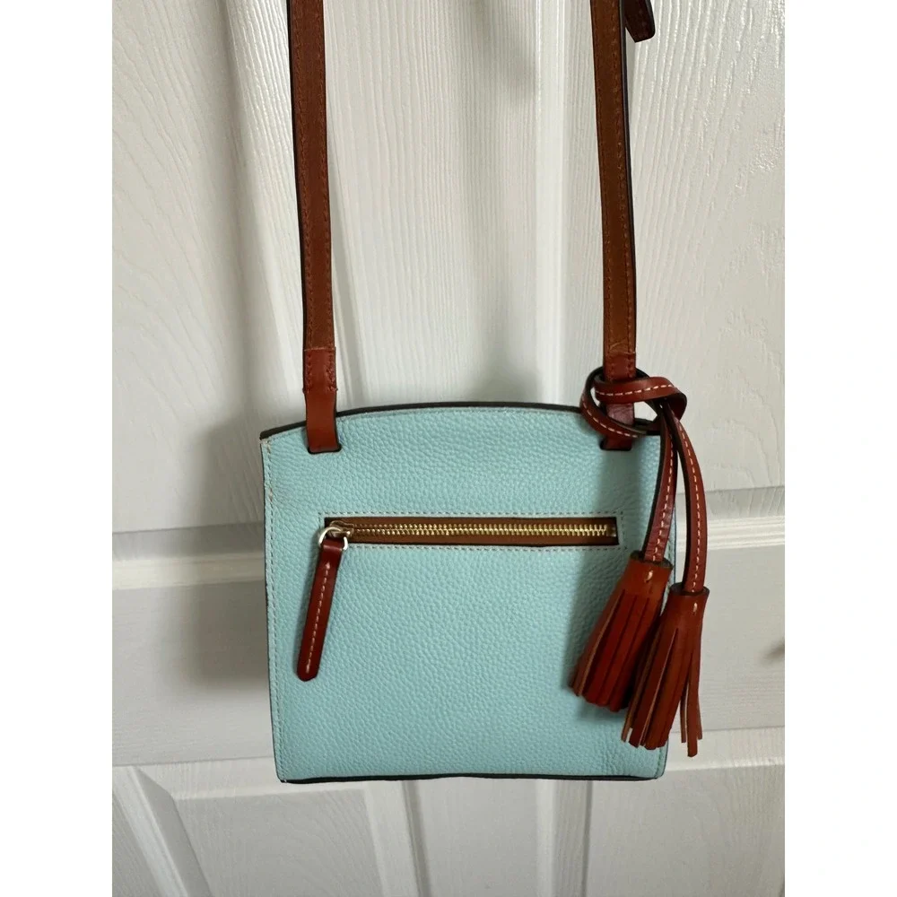 This is a Dooney & Bourke Pebble Grain East/West Flap Crossbody in a light blue